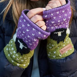 Pachamama Black Sheep Handwarmer Purple. These Pachamama Handwarmers  are knitted in Nepal by local villagers using local wools and natural dyes to UK designs. Sometimes called fingerless gloves, they feature a delightful black and white sheep pattern ove