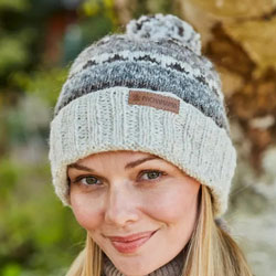 Pachamama Classic Fairisle Roll Back Bobble Beanie Natural. These Pachamama Bobble Beanies are knitted in Nepal by local villagers using local wools & natural dyes to UK designs..They feature an oat coloured, roll back, ribbed design. The beanie has bands