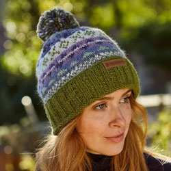 Pachamama Classic Fairisle Roll Back Bobble Beanie Olive. These Pachamama Bobble Beanies are knitted in Nepal by local villagers using local wools & natural dyes to UK designs. They feature a green coloured roll back, plus bands of patterned green, oat an