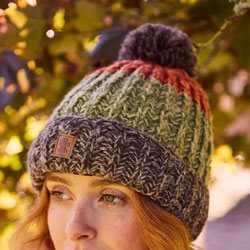 Pachamama Cotopaxi Bobble Beanie Earth. These Pachamama Bobble Beanies are knitted in Nepal by local villagers using local wools and natural dyes to UK designs. They feature very earthy tones of brown, orange and green in thick bands finished with a brown