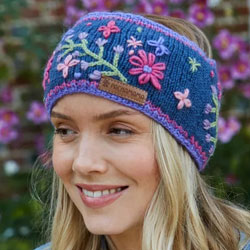 Pachamama Hampton Court Headband. These Pachamama Headbands are knitted in Nepal by local villagers using local wools and natural dyes to UK designs. Each headband features a navy blue background with embroided pink, lilac and green flowers, finished with